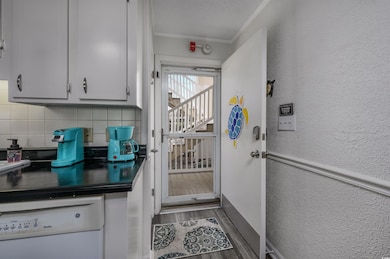 Kitchen featuring crown molding, dishwasher, dark 