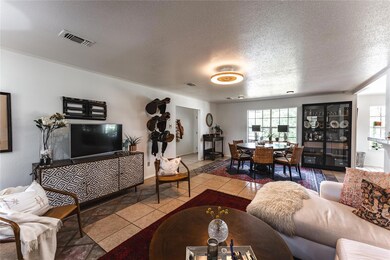 Tiled living room with a textured ceiling and ple