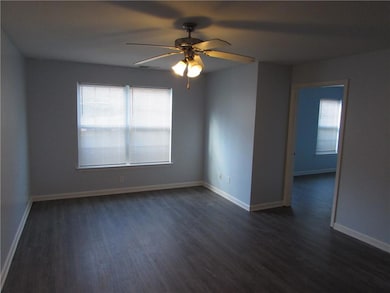Unfurnished room with baseboards, dark wood-style 
