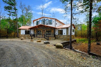 View of front of house with stone siding, a porch, and a metal roof