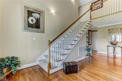 View of the two-story Entry showing the hardwood flooring and wall sconce accent lighting.  Not shown in this view is the decorative cut glass front entry door and a coat closet.