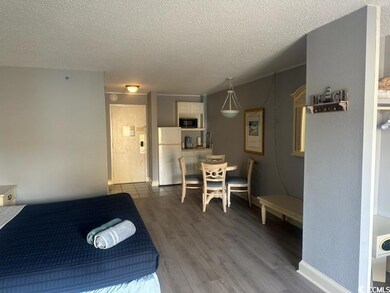 Bedroom featuring white refrigerator, a textured c