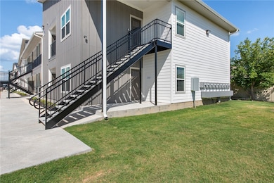 Rear view of house with stairs and a yard