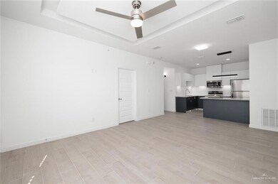 Unfurnished living room with light wood-type flooring, sink, and ceiling fan