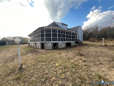 Rear view of house with a screen in wrap around porch and a lawn