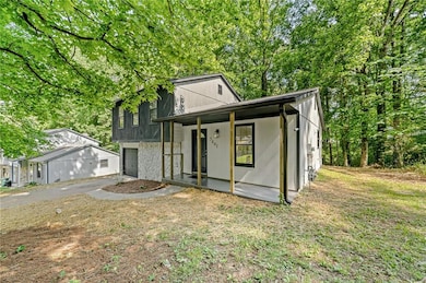 Tri-level home featuring covered porch, a garage, and asphalt driveway