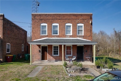 View of property with brick siding, a porch, and a