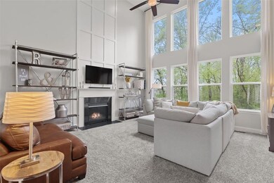 Soaring 2-story great room with a wall of windows overlooking the woods!