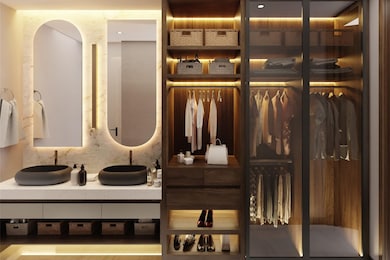 This primary bathroom exudes luxury and functionality, perfectly tailored for modern living. To the side, a large walk-in closet seamlessly integrates with the bathroom, providing ample storage with its rich, dark wood finish. This cohesive design offers a refined contrast to the bathroom's lighter tones, creating a harmonious balance between warmth and modernity.