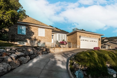 View of front of home featuring brick siding, concrete driveway, and an attached garage