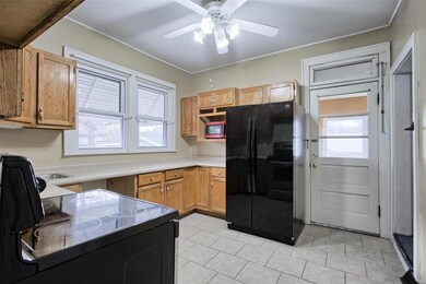 Freshly painted kitchen with quality cabinets leads to enclosed back porch area