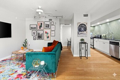 Living room featuring ceiling fan, light wood fin