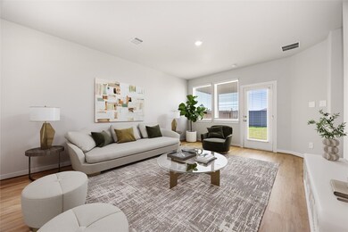 This bright and spacious living area features an open layout with large windows that fill the space with natural light. Elegant flooring and soft neutral tones create a warm, modern feel, while direct access to the backyard enhances indoor-outdoor living.