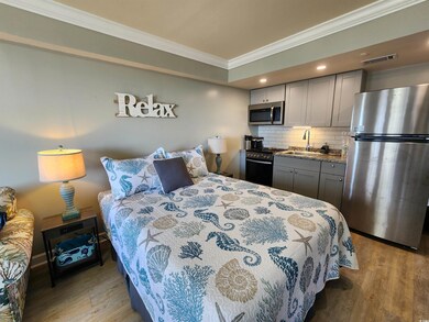Bedroom featuring ornamental molding, freestanding refrigerator, recessed lighting, and light wood-style floors