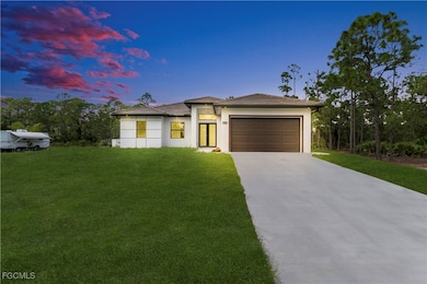Prairie-style house featuring concrete driveway, a lawn, a garage, and stucco siding