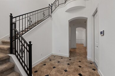Stairs with arched walkways, baseboards, and tile