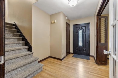 Foyer entrance with stairs and light wood-style floors