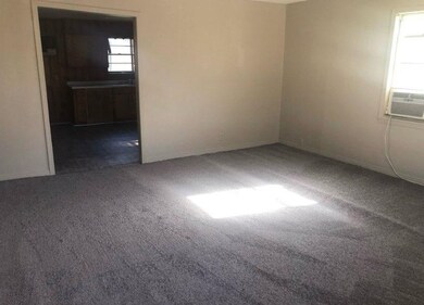 Carpeted empty room featuring cooling unit and bas