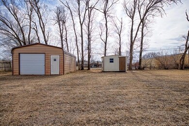 View of yard with two  outbuildings and fence