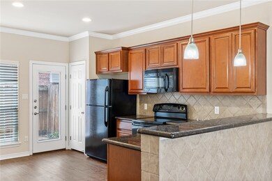 Kitchen with dark wood-type flooring, dark stone c