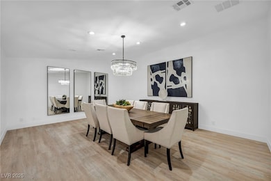 Dining space with a chandelier, light wood-style f
