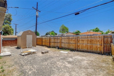 Fenced backyard featuring a shed