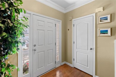 Foyer featuring, wood finished floors, and crown molding