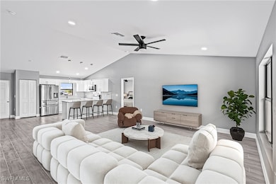 Living area featuring a ceiling fan, baseboards, v