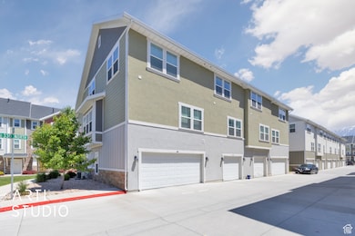 View of building exterior featuring a residential view, an attached garage, and driveway