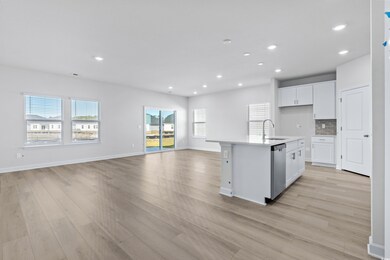 Kitchen featuring dishwasher, sink, light hardwood