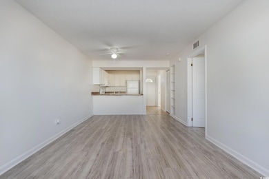 Unfurnished living room with ceiling fan, light ha