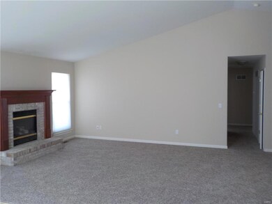 family room with vaulted ceilings and new carpet and paint. 