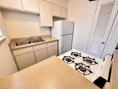 Kitchen featuring a sink, white appliances, light