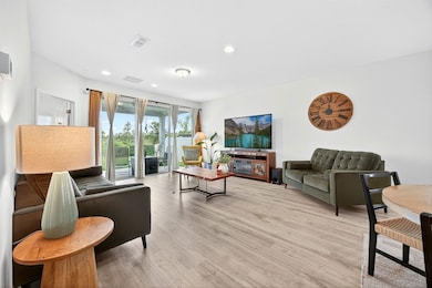 Living area with light wood finished floors and recessed lighting