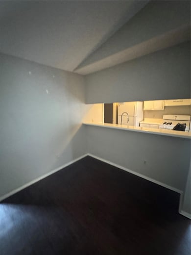 Unfurnished room featuring vaulted ceiling, baseb