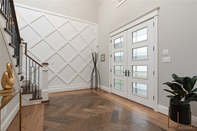 Entryway with a towering ceiling, herringbone floo
