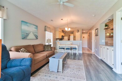 Living room with ceiling fan with notable chandeli