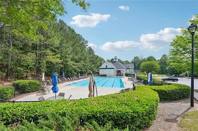 Community pool with fence, a patio area, and view 