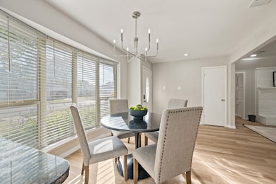Dining area featuring light wood-type flooring, recessed lighting, and a chandelier