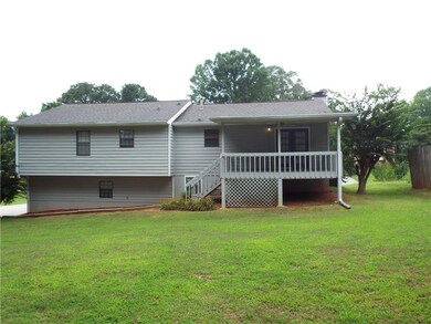 Rear view of house with a yard and stairs
