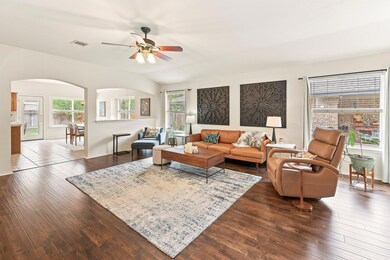 Living area with arched walkways, ceiling fan, vi
