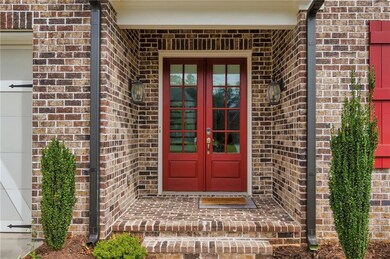 Property entrance featuring brick siding, french doors, and a garage
