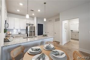 Kitchen with white cabinets, sink, stainless steel