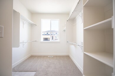 Spacious walk-in closet in primary suite with hookups for stackable washer and dryer.