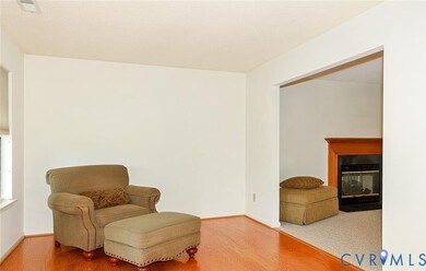 Sitting room with a multi sided fireplace, wood finished floors, and a textured ceiling