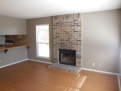 Unfurnished living room with baseboards, a brick 