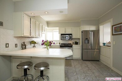 Open, bright kitchen with stainless appliances.