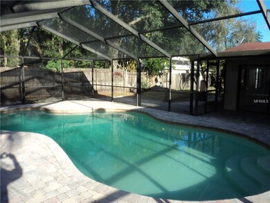 In ground pool inside pool cage from front to back
