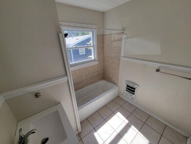 Bathroom featuring light tile patterned floors, a bathtub, heating unit, a textured ceiling, and a shower