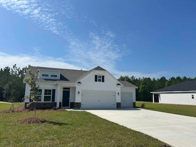View of front of home with driveway, stone siding, a front yard, an attached garage, and a shingled roof